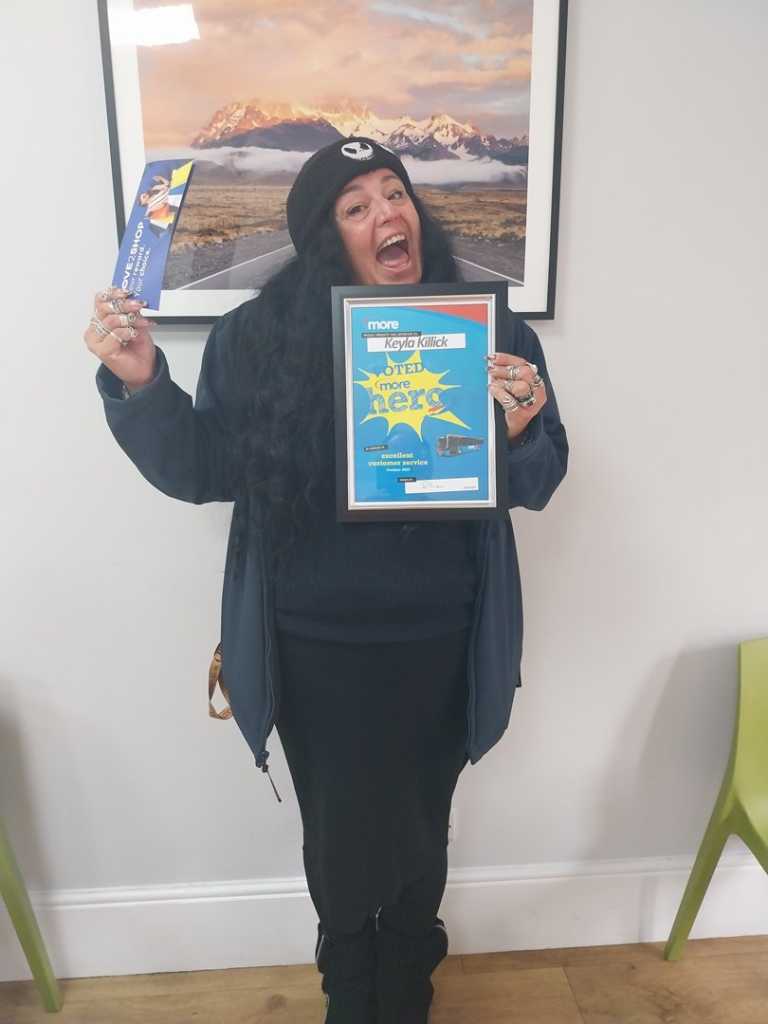 Keyla holding up her certificate and voucher