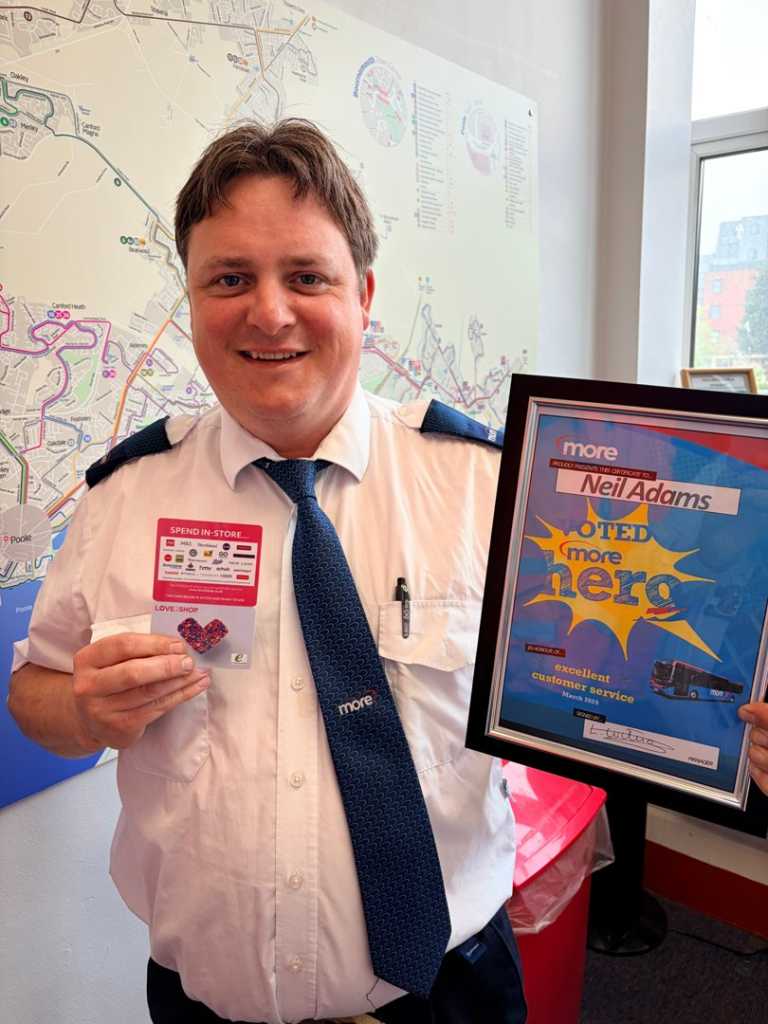 Neil holding up his certificate and voucher